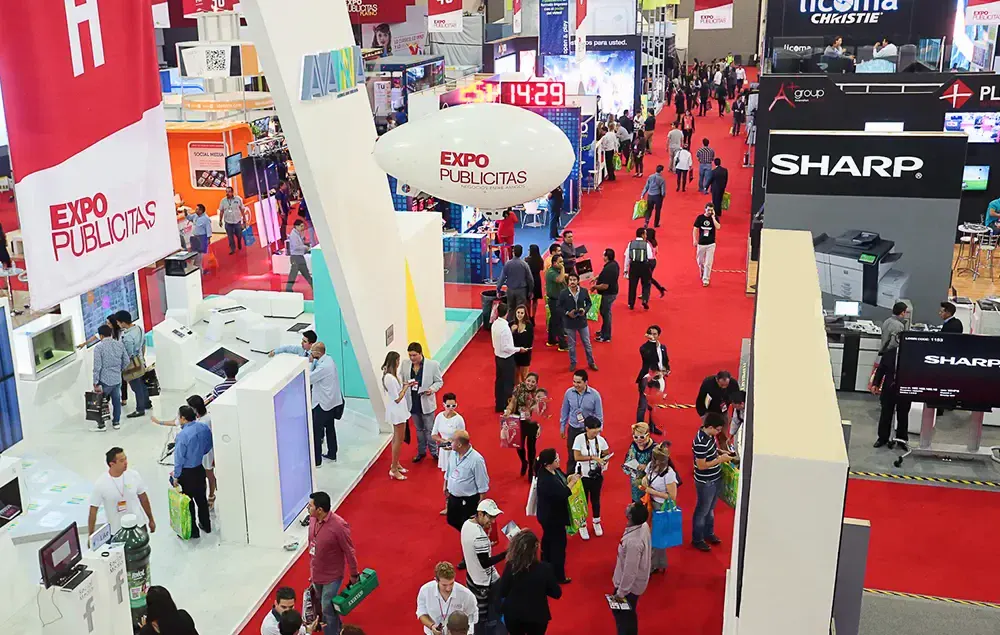 Vista aérea del piso de exposición de ExpoPublicitas con stands, asistentes profesionales y marcas expositoras durante el evento, representando oportunidades de patrocinio B2B, generación de leads y posicionamiento de marca en marketing, publicidad y tecnología.