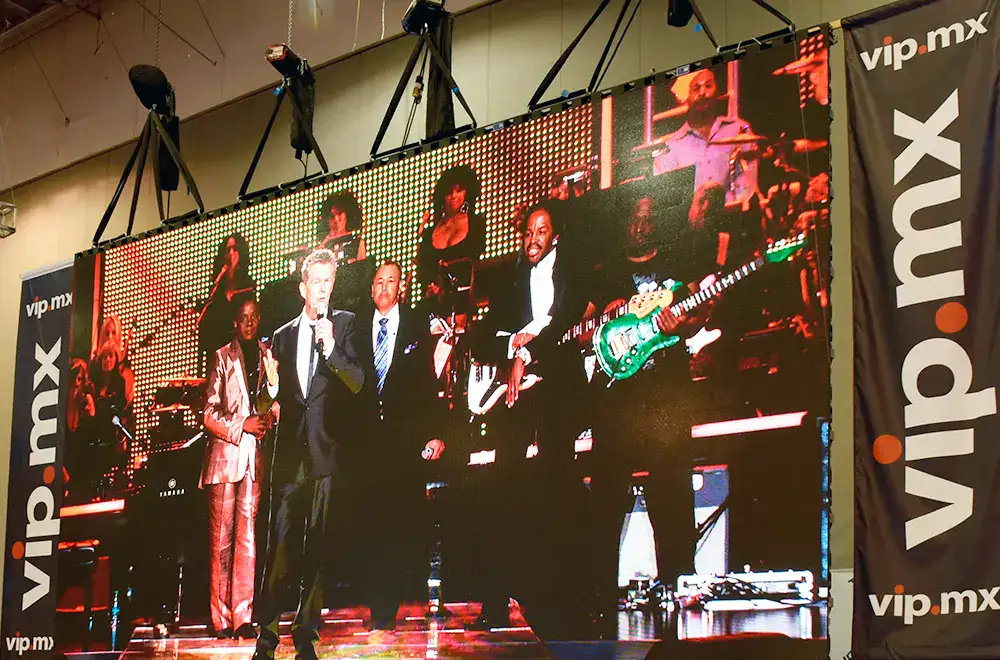 Escenario con pantallas digitales y presentadores durante un evento de publicidad y marketing en México.