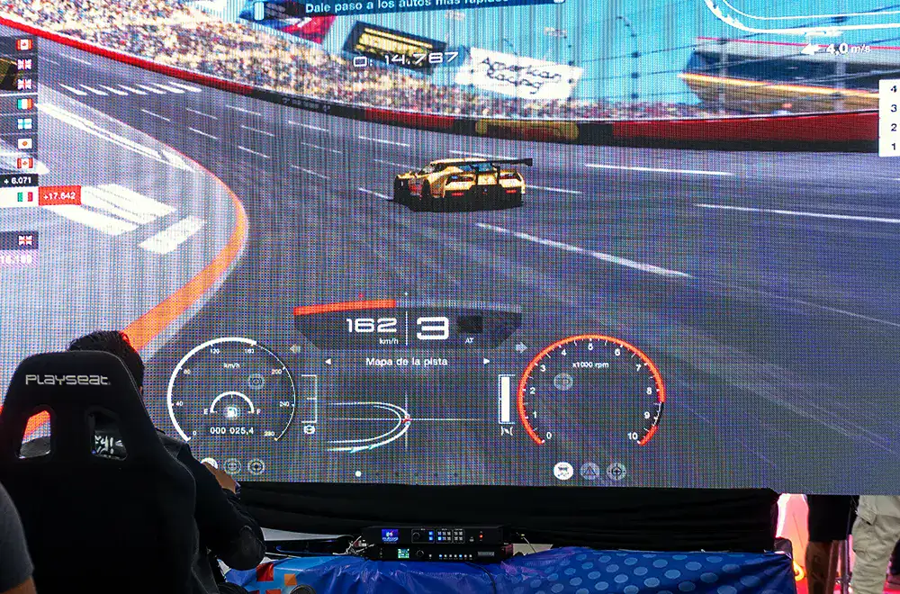 Imagen de una persona utilizando un simulador de manejo frente a un videojuego, mostrando cómo la publicidad puede integrarse de forma dinámica en entornos interactivos.