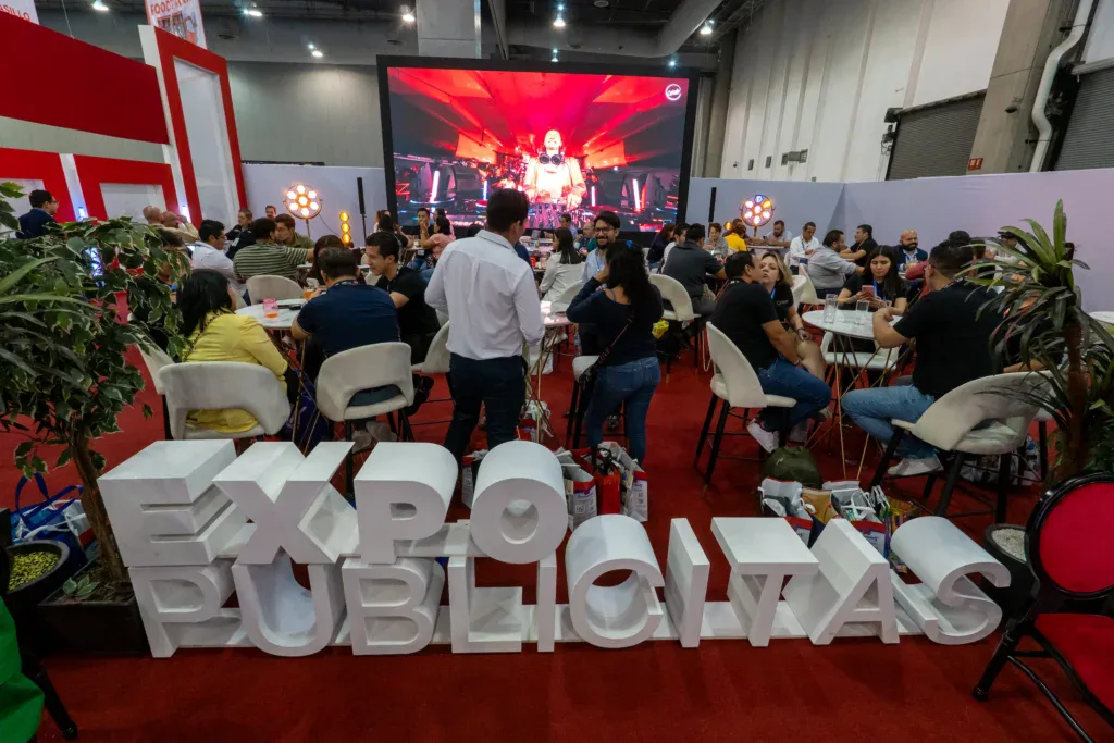 Ambiente principal de ExpoPublicitas durante una jornada de networking, con expositores, activaciones de marca y asistentes reunidos en el pabellón central del evento.