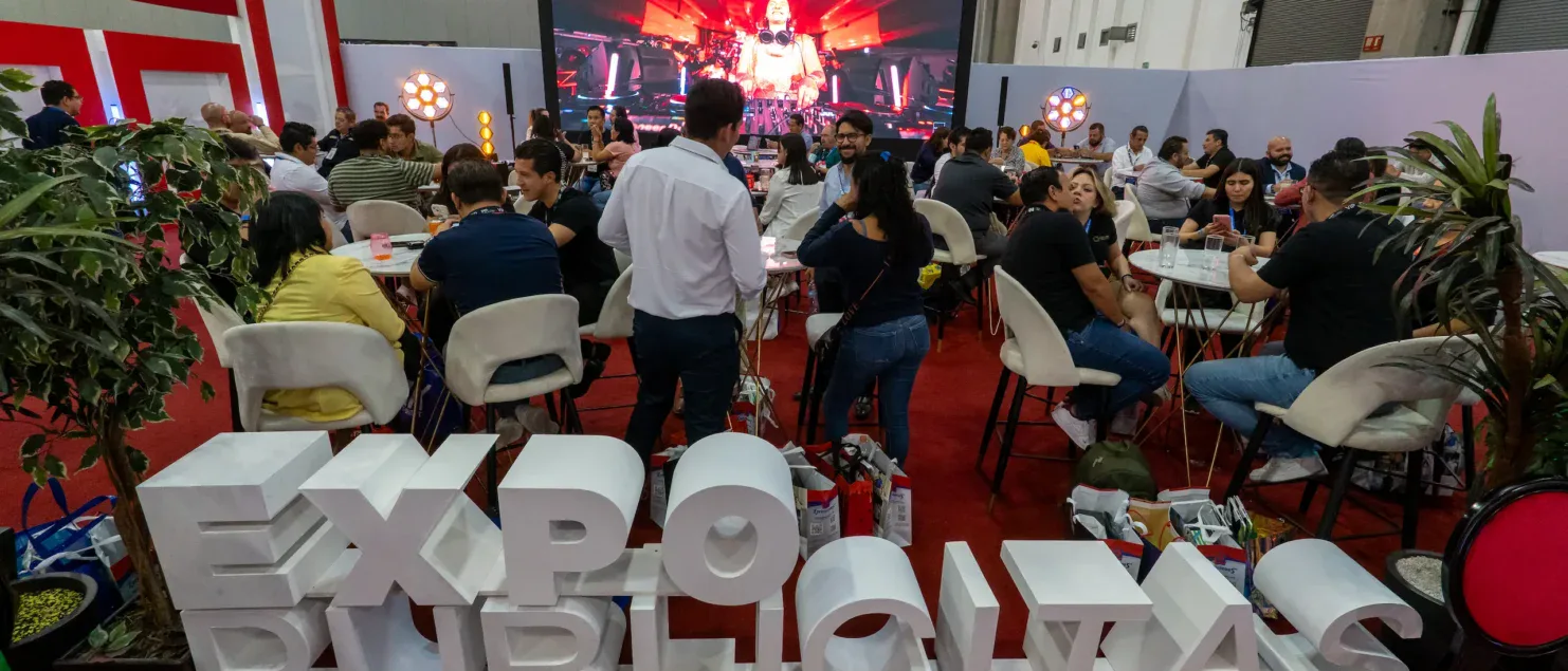 Ambiente principal de ExpoPublicitas durante una jornada de networking, con expositores, activaciones de marca y asistentes reunidos en el pabellón central del evento.
