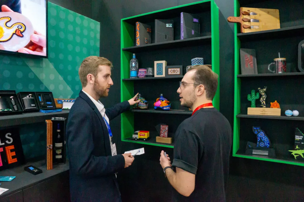 Ejecutivos conversando en un stand de digital signage durante un evento B2B, representando reuniones cara a cara, toma de decisiones y generación de oportunidades comerciales en ExpoPublicitas.